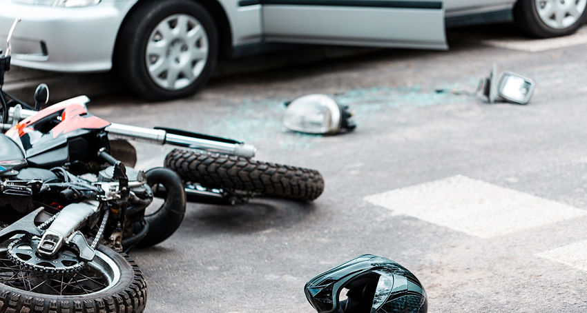 motorcycle crash on highway with helmet and broken glass on ground